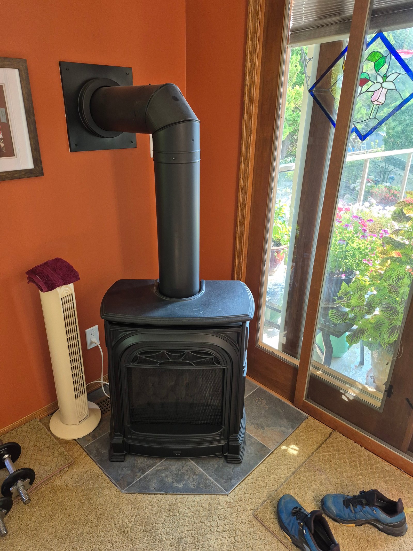 Freestanding gas stove installed against an orange wall