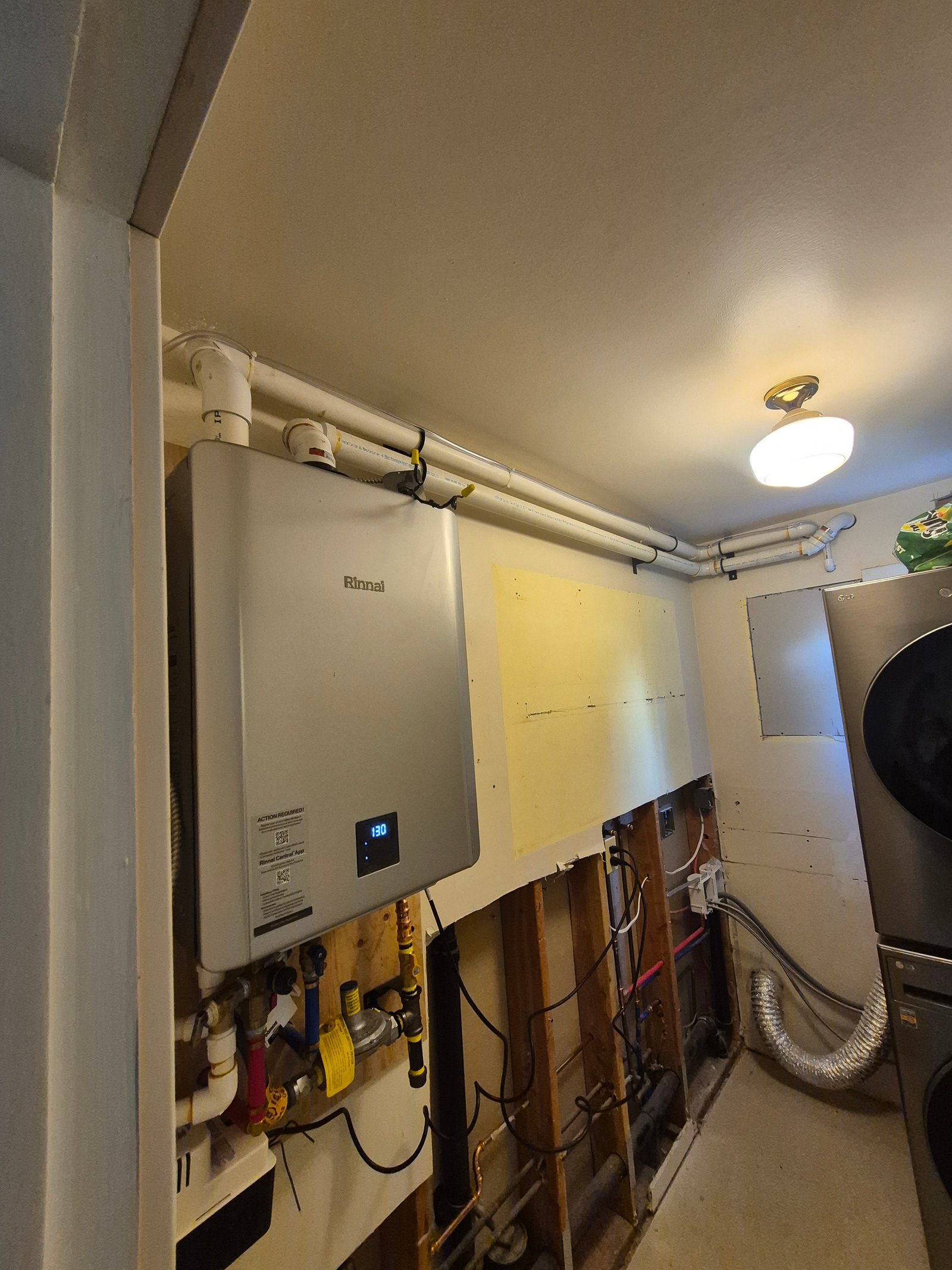 Tankless water heater installed beside a laundry area