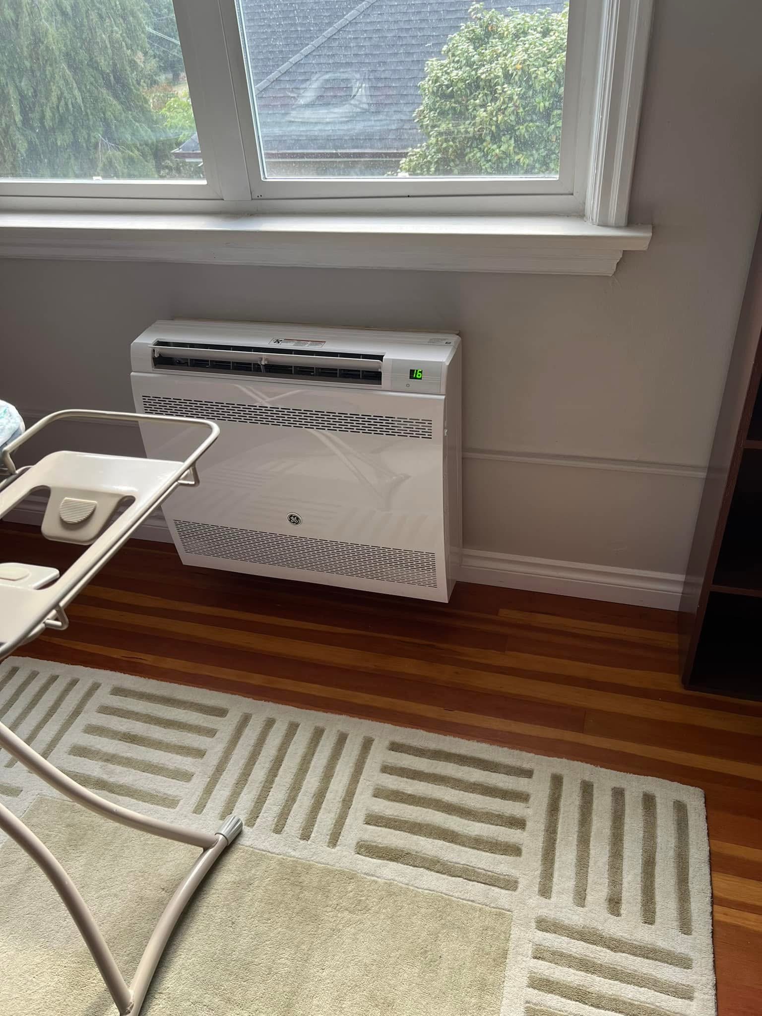 Floor-mounted ductless heat pump unit installed beneath a window